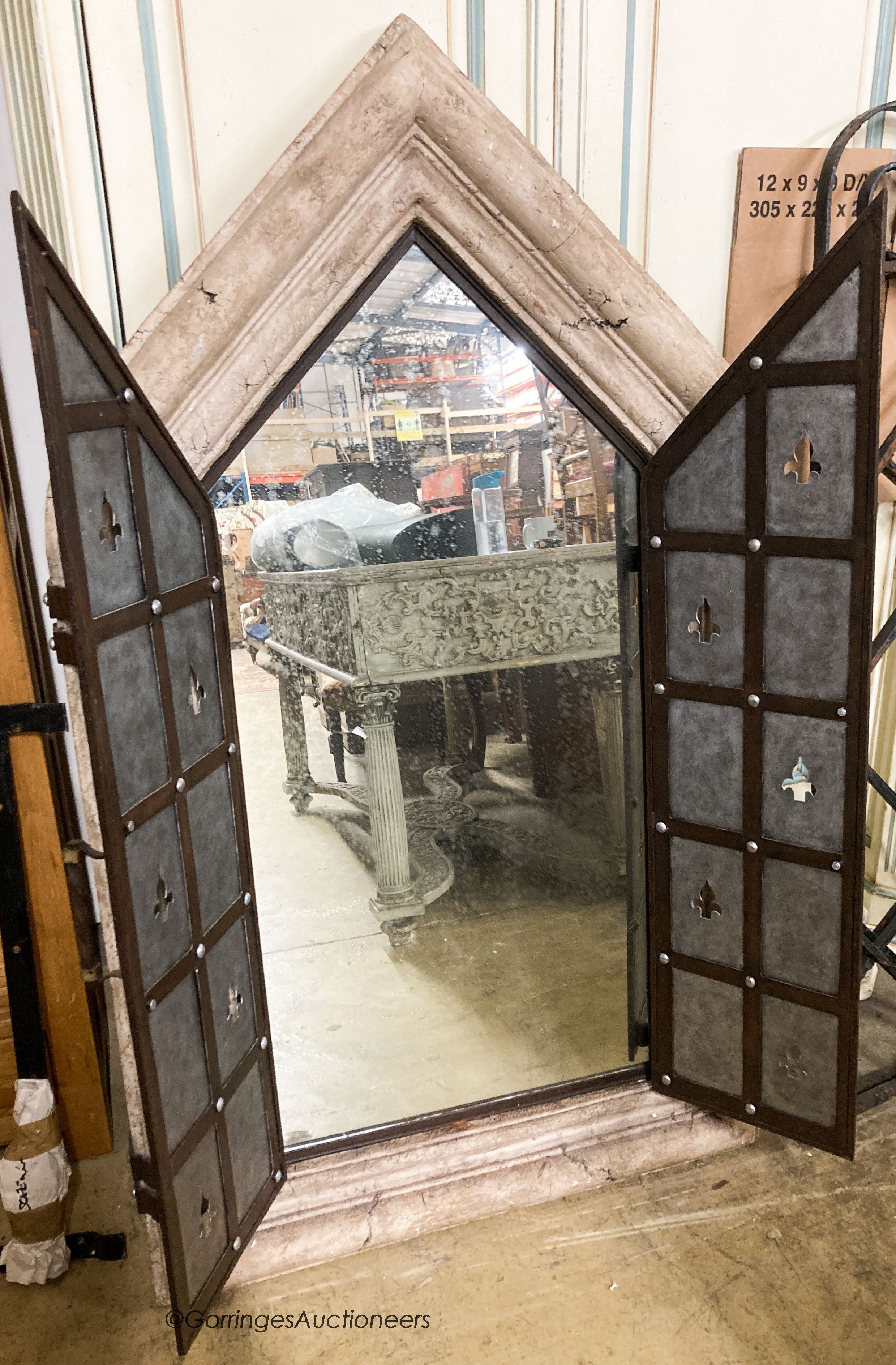 A medieval style simulated stone and wrought iron wall mirror, width 92cm, height 156cm